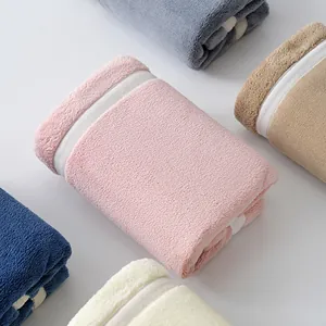 Thick coral fleece towels in various colors showing soft texture and herringbone border