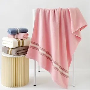 Ensemble de serviettes en coton doux avec rayures contrastées sur une chaise de maison