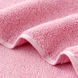 Soft pink cotton towel featuring dense loop pile texture and fine stitched edge design