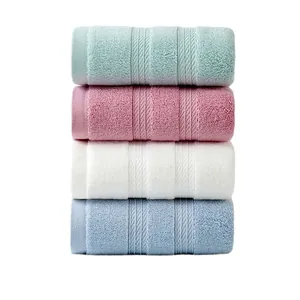 Stack of four colorful thick cotton towels in mint, pink, white, and light blue