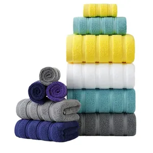 Set di asciugamani in cotone spesso con trama a righe in vari colori su sfondo bianco