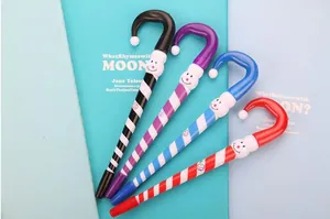 Macro detail of Christmas candy cane ballpoint pens with snowman topper on notebooks