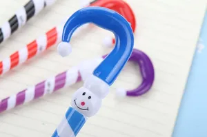 Close-up of candy cane Christmas pens with snowman faces on lined notebook paper