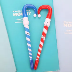 Christmas candy cane ballpoint pens with cute smiley face patterns on blue book
