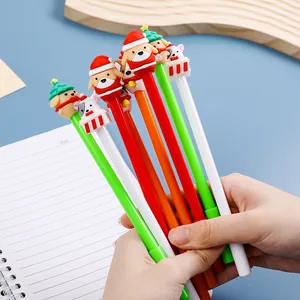 Main tenant divers stylos gel de Noël avec des figurines d'animaux festifs mignons