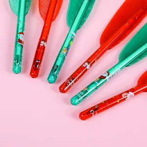 Détail de stylos gel de Noël avec motifs Père Noël et rennes sur fond rose tendre