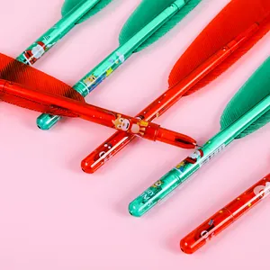Gros plan de stylos plume de Noël rouges et verts avec motifs festifs Merry Christmas