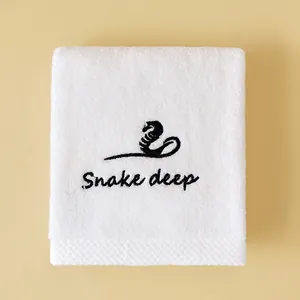 Soft absorbent white cotton face towel with minimalist black snake embroidery detail