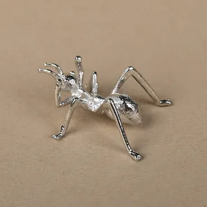 Creative silver alloy ant sculpture serving as a decorative crystal ball display stand