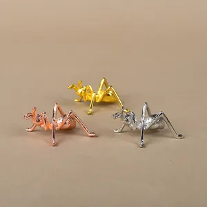 Detailed close-up of metal ant figurines in rose gold, gold, and silver finishes