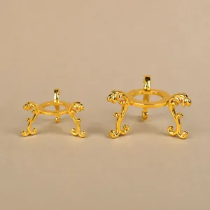Detailed view of ornate gold metal tripod stands for crystal balls and mineral spheres