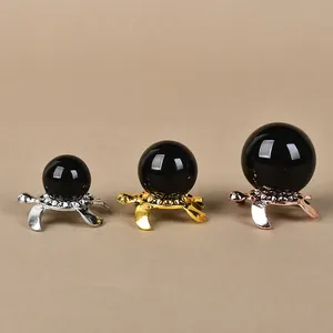 Three turtle-shaped metal crystal ball stands in silver, gold and rose gold finishes