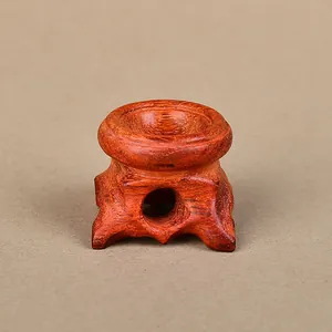 Detail of hand-carved rosewood stand with circular groove for crystal ball display