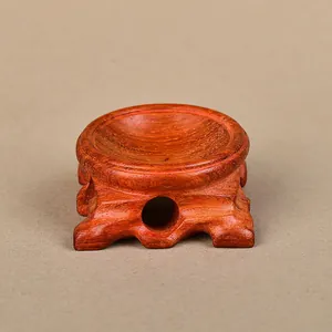 Macro detail of antique dark red wood ball display stand with carved hollow feet