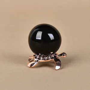Polished black obsidian crystal ball on rose gold turtle stand with sparkling rhinestones