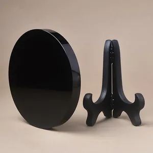 Polished obsidian decorative disc mirror on black display stand for home decor
