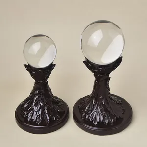 Detail of leaf carved resin display stand with transparent crystal balls in two sizes