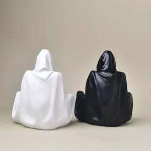 Detail of minimalist black and white hooded figure resin pedestals for crystal balls
