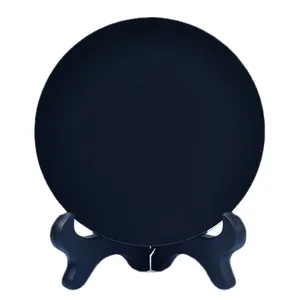 Polished black obsidian circular disc display with a black folding tripod stand base