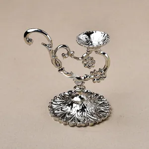 Close-up of floral relief carvings on polished silver vintage metal candle holder base