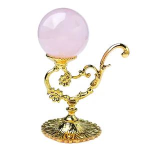 Golden iron display stand for crystal ball with vintage floral carving and pink stone