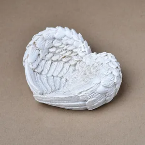 Vue détaillée de plateau en forme de cœur ailes d'ange blanches avec textures plumes