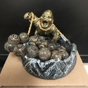 Vue détaillée d'une sculpture de gorille dorée avec plateau en pierre et perles d'agate