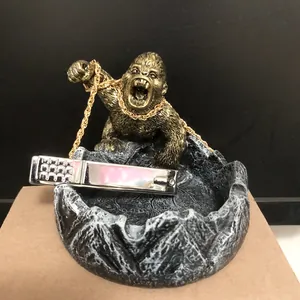 Gros plan d'une figurine de gorille en bronze sur un socle de cendrier en pierre