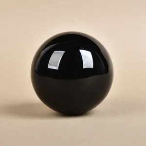 Polished black obsidian crystal sphere with mirror finish for home decor and feng shui