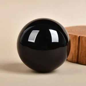 Polished obsidian crystal ball on wood stand for home feng shui decor and meditation