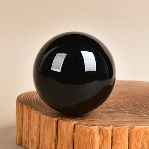 Polished black obsidian crystal ball with natural wood base for home decoration