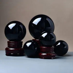 Polished obsidian spheres in various sizes set on decorative dark wood display stands