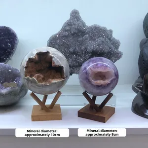 Detail view of 10cm and 8cm crystal geode spheres on natural wood tripod stands