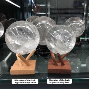 Detail view of 8cm and 10cm clear crystal balls on minimalist geometric wooden stands
