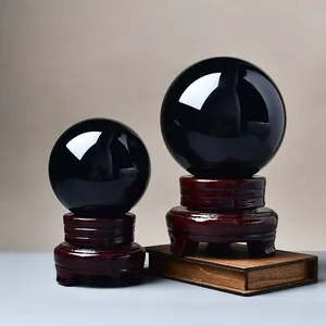 Polished black obsidian feng shui crystal balls on wooden stands in two sizes