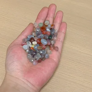 Close-up of polished colorful natural agate stones held in hand for size visualization