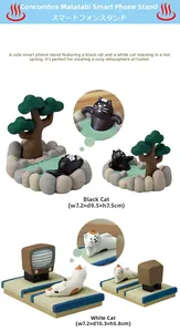 Detailweergave van Japanse kattenbeeldjes met retro-tv en onsen-telefoonhouderbasis
