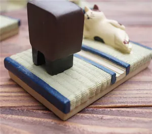 Detail van Japanse kattenfiguur op tatami-mat basis gebruikt als houder voor mobiele telefoon