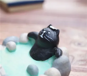 Macro-opname van een miniatuur zwarte kat die in een kunstmatige warmwaterbron baadt