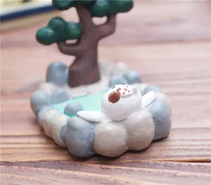 Detailopname van een Japans hars kattenbeeldje in een warmwaterbron op houten tafel