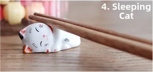 Macro shot of a sleeping white ceramic lucky cat chopstick rest on a wooden table