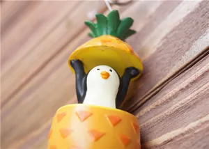 Kreativer Pinguin und Ananas Harz Schlüsselanhänger Anhänger auf Holz Hintergrund
