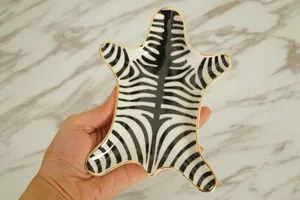 Close-up of zebra stripe ceramic jewelry tray with premium gold gilded edges