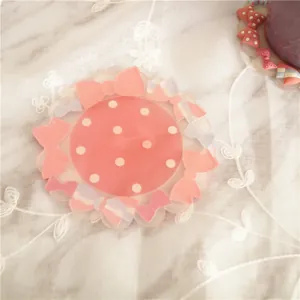 Pink polka dot PVC coaster with colorful 3D bow decorations on a white lace background