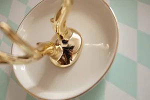 Bandeja de cerámica marfil con astas doradas para guardar anillos y joyas