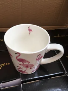 Top view of a white ceramic mug featuring realistic pink flamingo prints and interior detail