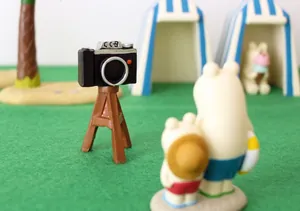 Appareil photo miniature rétro sur trépied avec figurines d'ours à la plage