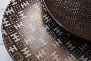 Modern ceramic dining plate with geometric caramel gold patterns and luxury relief texture
