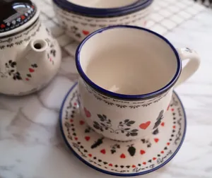 Gedetailleerd bovenaanzicht van vintage keramisch Alice-servies met sprookjesmotief