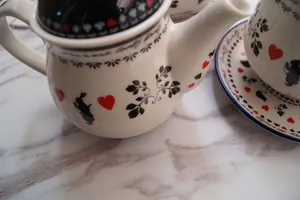 Detail van Alice in Wonderland theepot met kaartpatronen en silhouet van een konijn